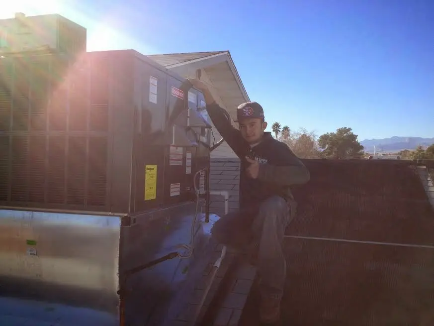 HVAC technician performing Boiler Repair on a rooftop unit in Murray